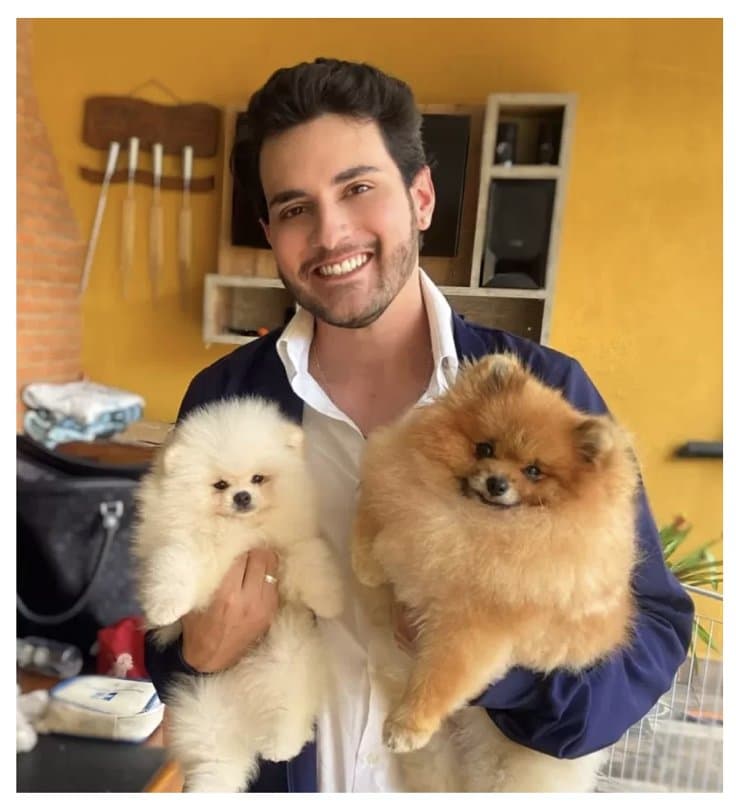 Dr. Bertoloni segurando dois cães da raça Spitz Alemão